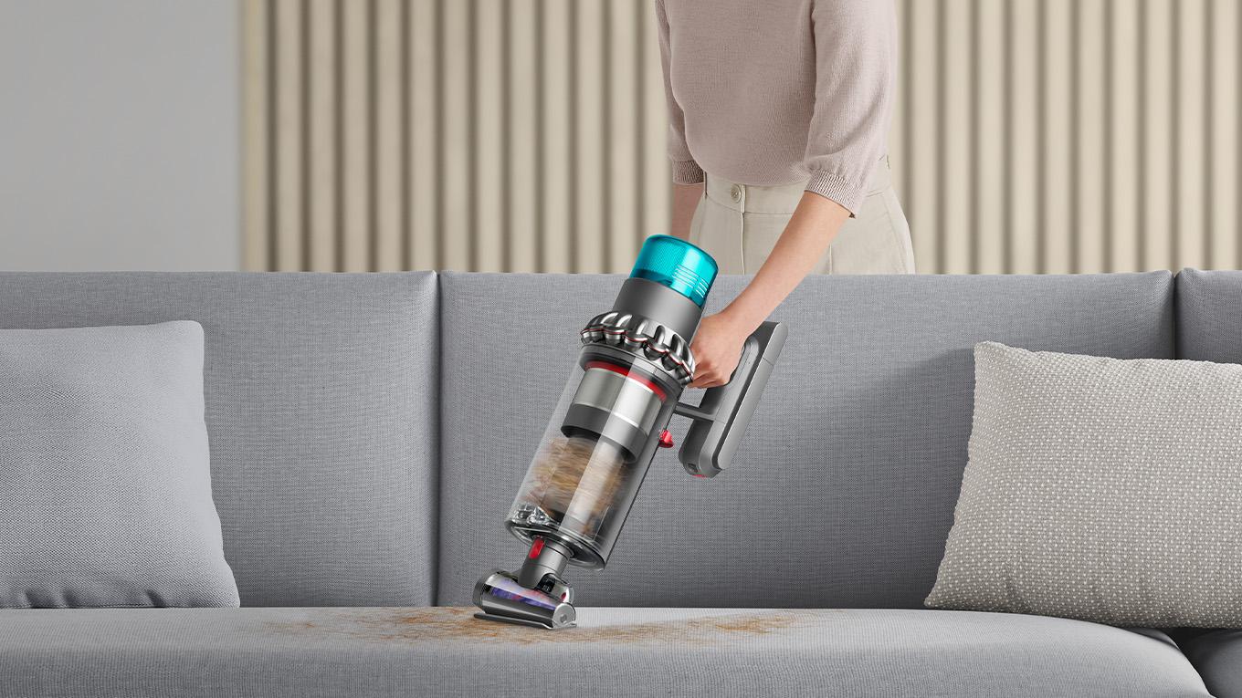 Dyson vacuum cleaner vacuuming pet hair off couch
